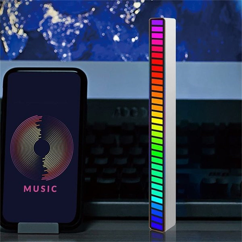"Trådlös ljudaktiverad RGB ljuslist i svart, reagerar på musik med färgat sken och skapar dynamisk atmosfär."
