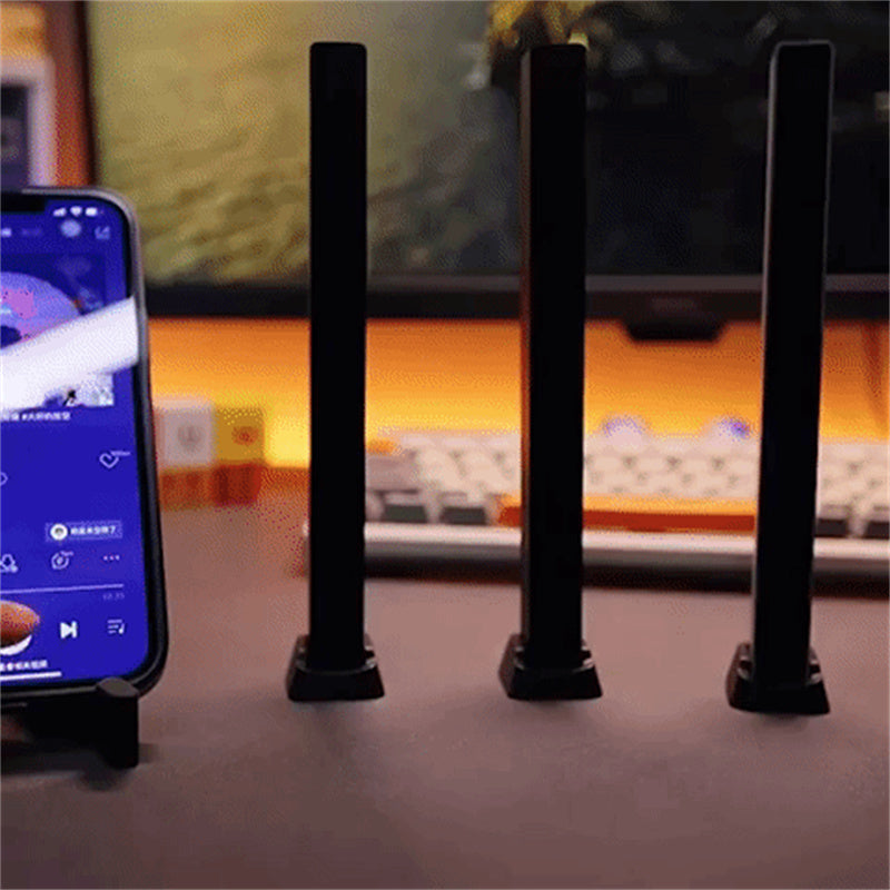 "Trådlös ljudaktiverad RGB ljuslist i svart, reagerar på musik med färgat sken och skapar dynamisk atmosfär."