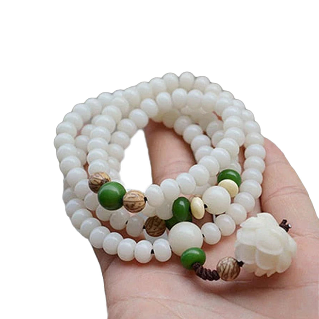 "Unisex Bodhi armband med vita Bodhi-frön och lotusblomma, främjar lugn och meditation, elegant design."