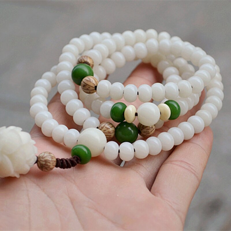 "Unisex Bodhi armband med vita Bodhi-frön och lotusblomma, främjar lugn och meditation, elegant design."