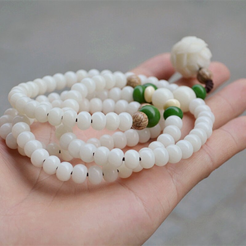 "Unisex Bodhi armband med vita Bodhi-frön och lotusblomma, främjar lugn och meditation, elegant design."