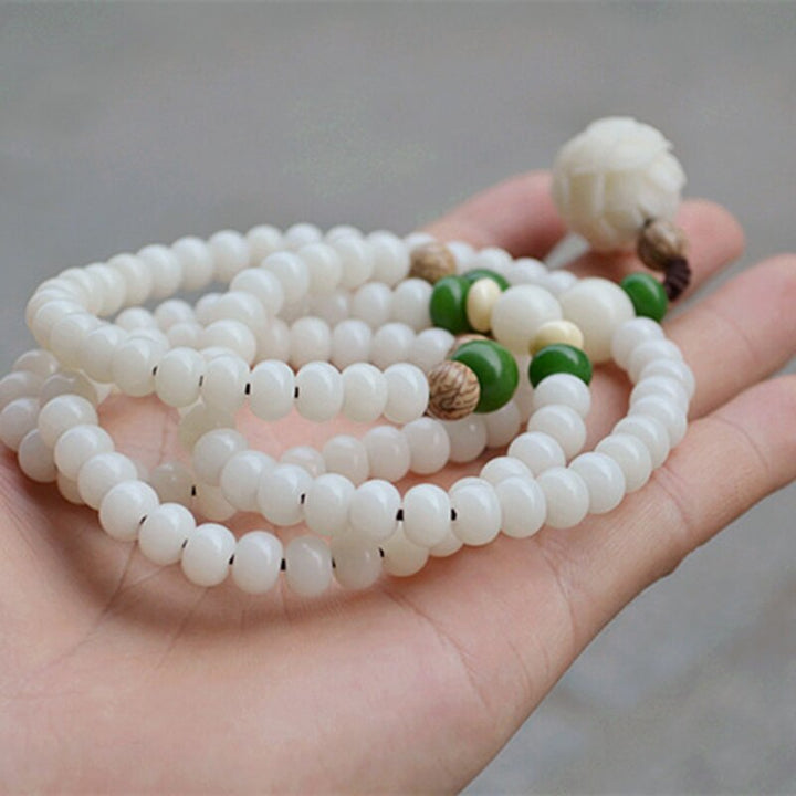 "Unisex Bodhi armband med vita Bodhi-frön och lotusblomma, främjar lugn och meditation, elegant design."