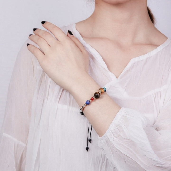 "Unisex kosmiskt solsystem armband i naturlig sten med färgglada pärlor som symboliserar planeter, justerbar passform."