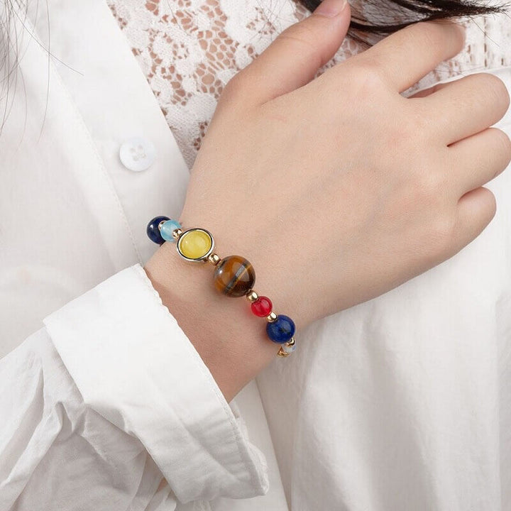 "Unisex kosmiskt solsystem armband i naturlig sten med färgglada pärlor som symboliserar planeter, justerbar passform."