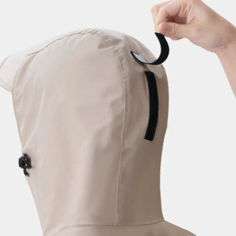 Unisex lång regnponcho buren av en person som går i regnet.