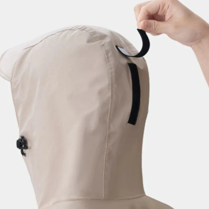 Unisex lång regnponcho buren av en person som går i regnet.