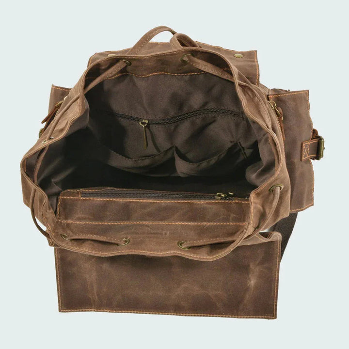 "Unisex ryggsäck i vintage stil, dragskostängning, vaxad canvas, brunt läder, ergonomiska axelband, stor förvaring."