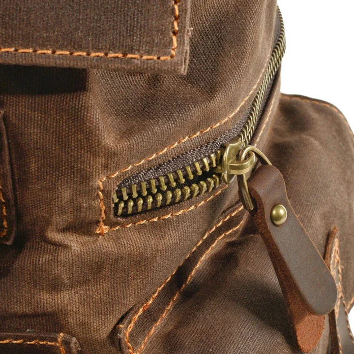 "Unisex ryggsäck i vintage stil, dragskostängning, vaxad canvas, brunt läder, ergonomiska axelband, stor förvaring."