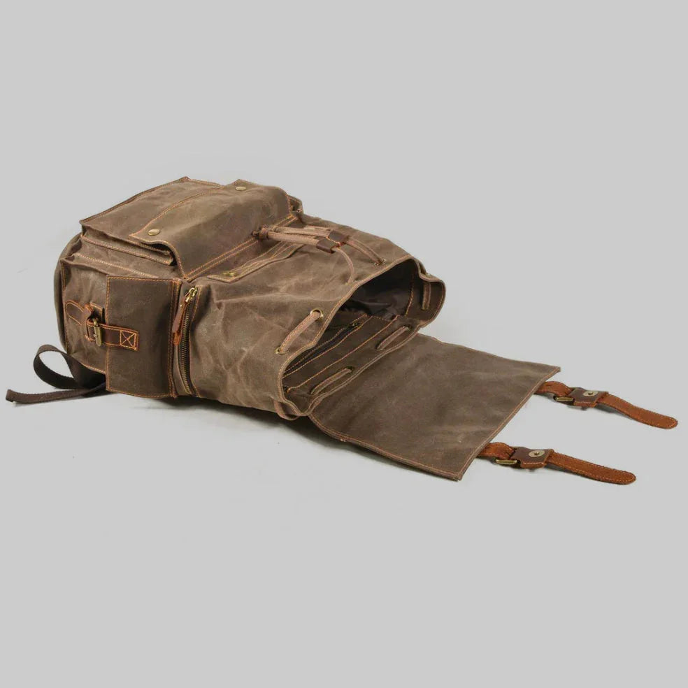 "Unisex ryggsäck i vintage stil, dragskostängning, vaxad canvas, brunt läder, ergonomiska axelband, stor förvaring."