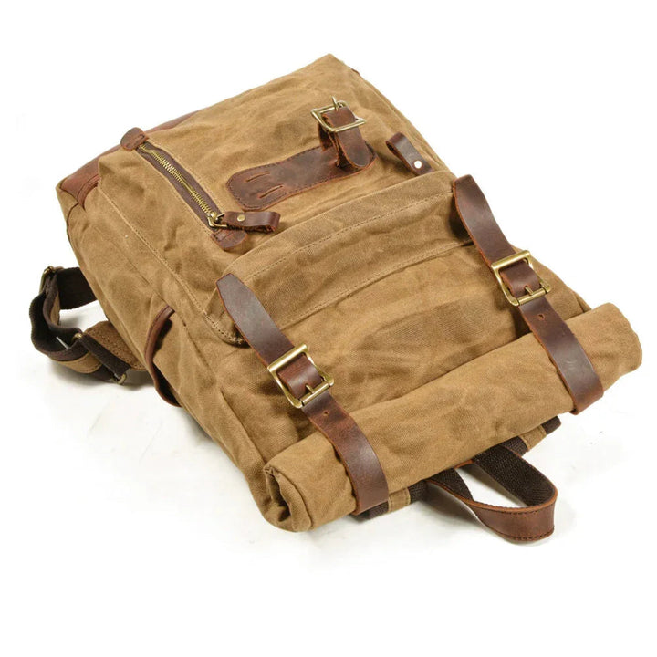 "Unisex vikbar vintage ryggsäck i vaxad canvas, stilren och funktionell, med vadderade axelremmar och flera fickor."
