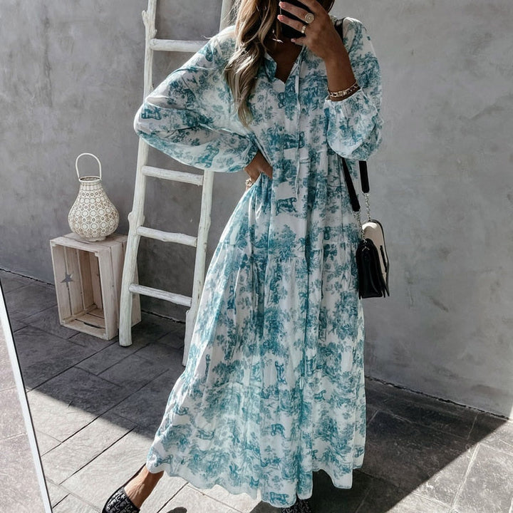 Vacker damklänning med v-ringning och långa ärmar, mjuka ruffle detaljer; perfekt för eleganta tillfällen och vardag.