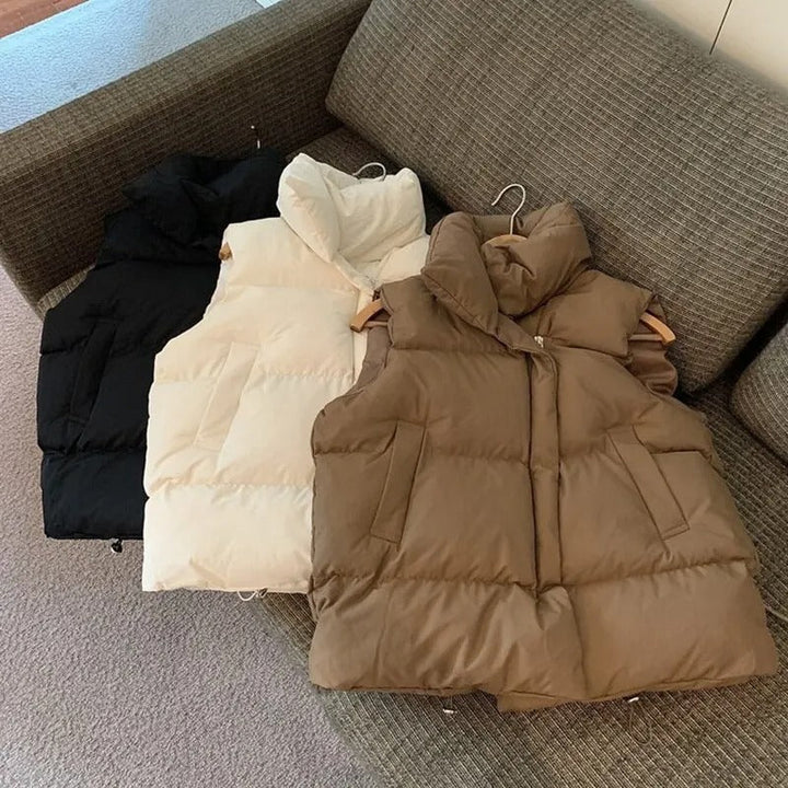 "Varm kvinnlig dunväst i beige, vindtät och stilren, perfekt för kyligt väder, kombinerar elegans med funktionalitet."