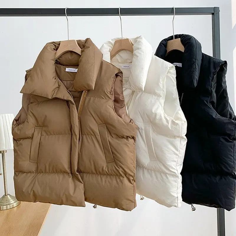 "Varm kvinnlig dunväst i beige, vindtät och stilren, perfekt för kyligt väder, kombinerar elegans med funktionalitet."