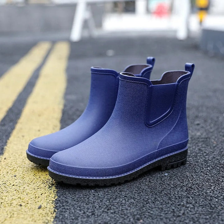 "Vattentäta halvhöga herrboots i syntetmaterial, elegant design, svart färg, perfekt för regniga dagar och stadsvandringar."