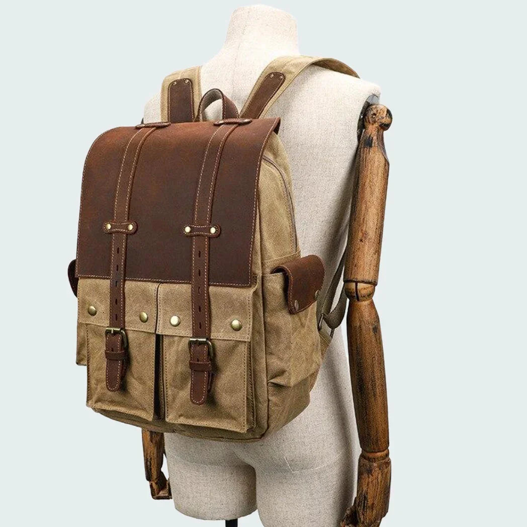 "Vintage kameraryggsäck i vaxad bomull och läder, herrmodell. Stilren design med bruna läderdetaljer och klassisk look."