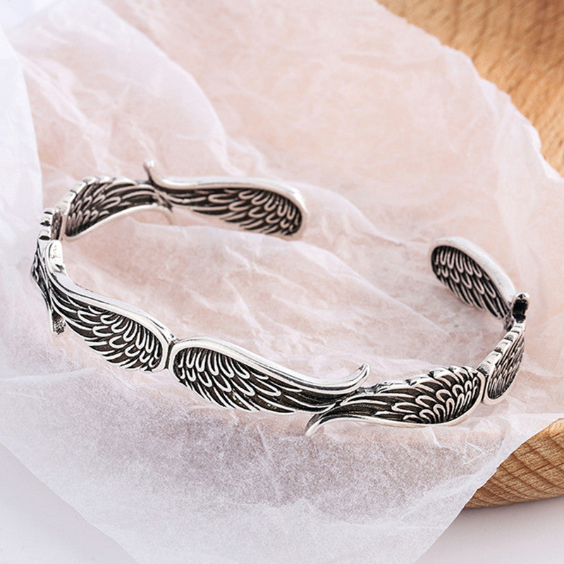 "Änglavingar armband i koppar vintagestil, unisex design, justerbar, symbol för skydd och mod, elegant och tidlös look."