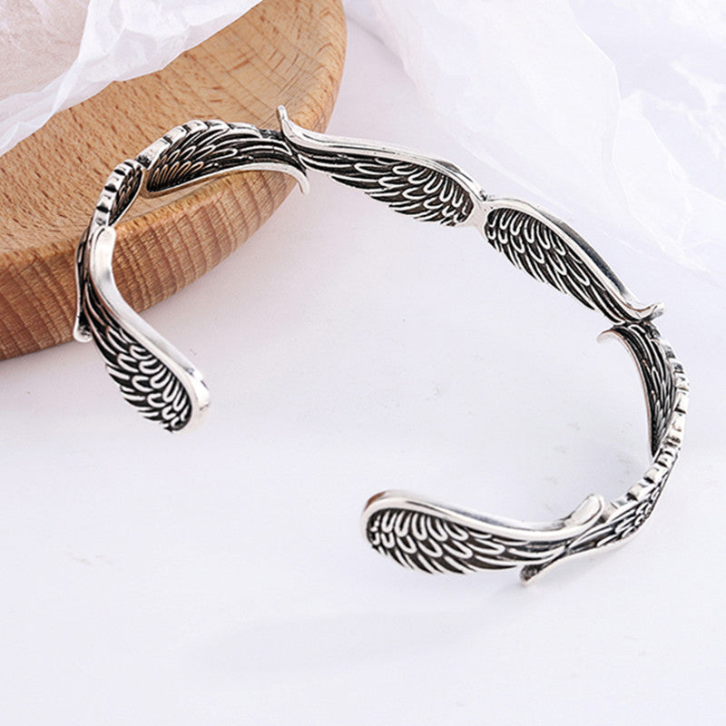 "Änglavingar armband i koppar vintagestil, unisex design, justerbar, symbol för skydd och mod, elegant och tidlös look."