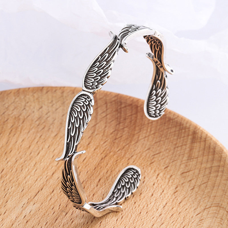 "Änglavingar armband i koppar vintagestil, unisex design, justerbar, symbol för skydd och mod, elegant och tidlös look."