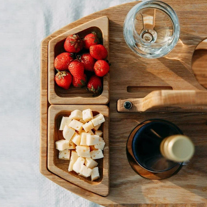 Mångsidigt utomhusbord; ett portabelt vinbord med glashållare och fack för snacks. Perfekt presentidé.