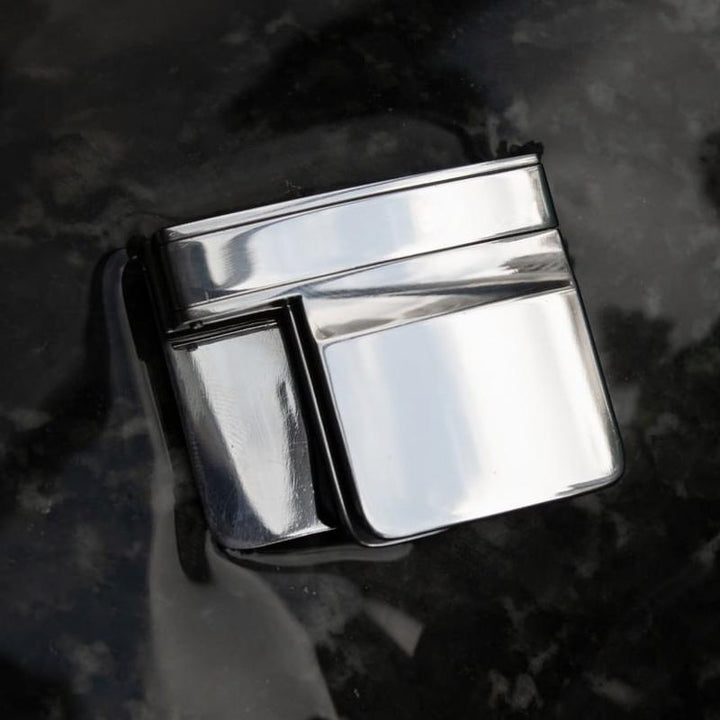 "Bältesjusteringsklämma i silver, kompakt och diskret design, ger perfekt passform för byxor och kjolar, elegant accessoar."