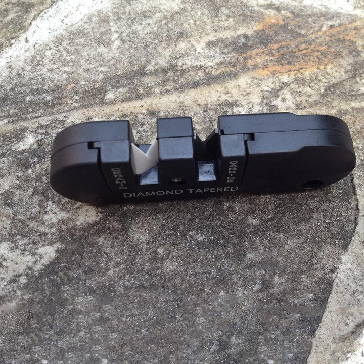 Bärbar 4-i-1 knivslipare i tungsten och stål, kompakt och stilren, perfekt för vildmark och kök, slipzoner för olika knivar.
