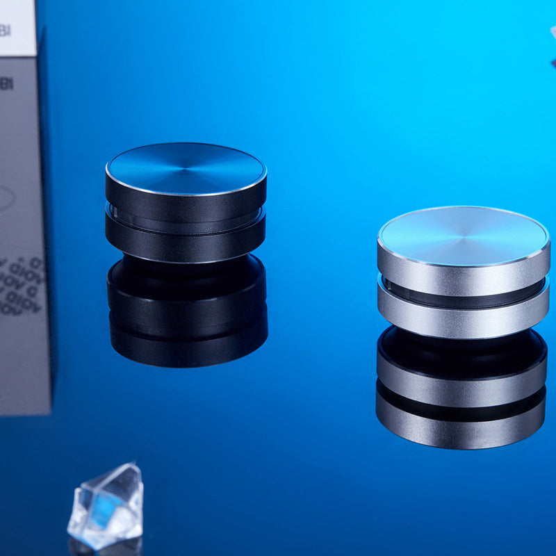 "Bärbar benledning Bluetooth-högtalare, kompakt och rund design, silverfärgad med grå detaljer, lätt att ta med."
