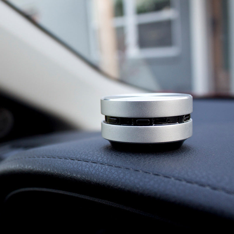 "Bärbar benledning Bluetooth-högtalare, kompakt och rund design, silverfärgad med grå detaljer, lätt att ta med."