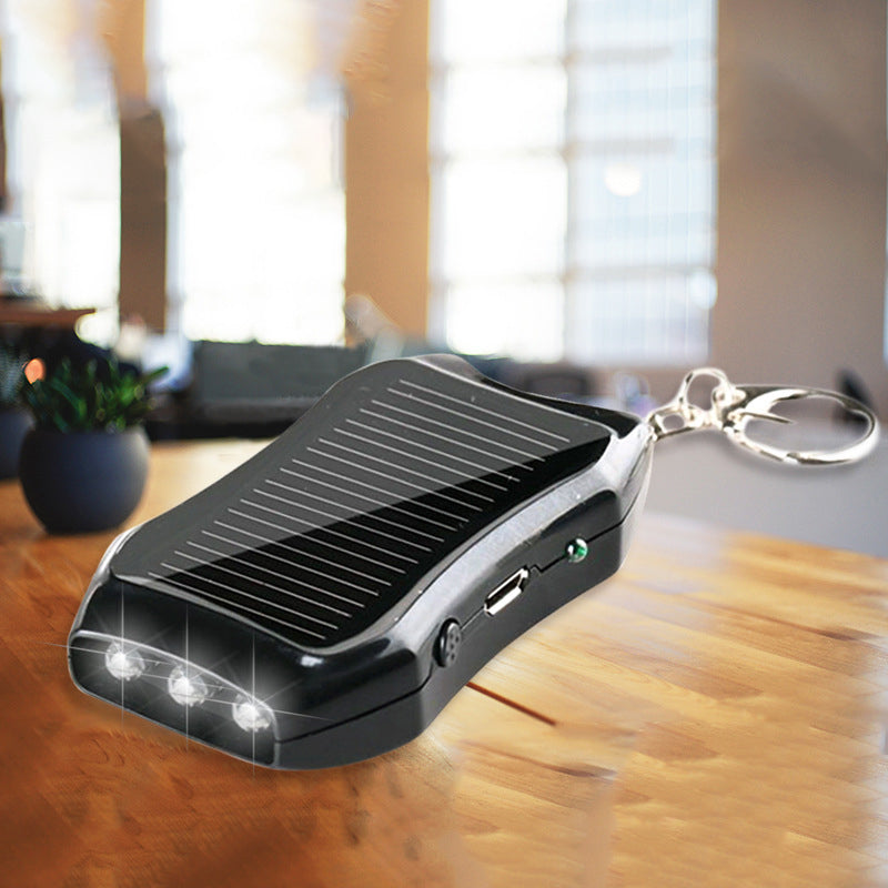 Bärbar mini powerbank på nyckelring, svart och vit, kompakt design, perfekt för resor och enkel att bära med sig.