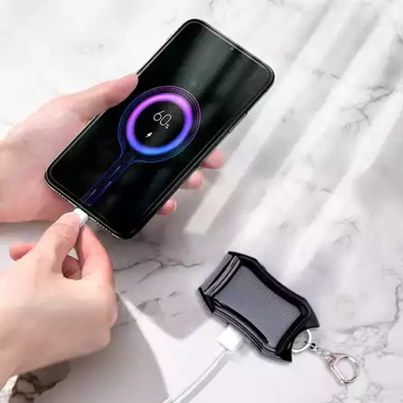 Bärbar mini powerbank på nyckelring, svart och vit, kompakt design, perfekt för resor och enkel att bära med sig.