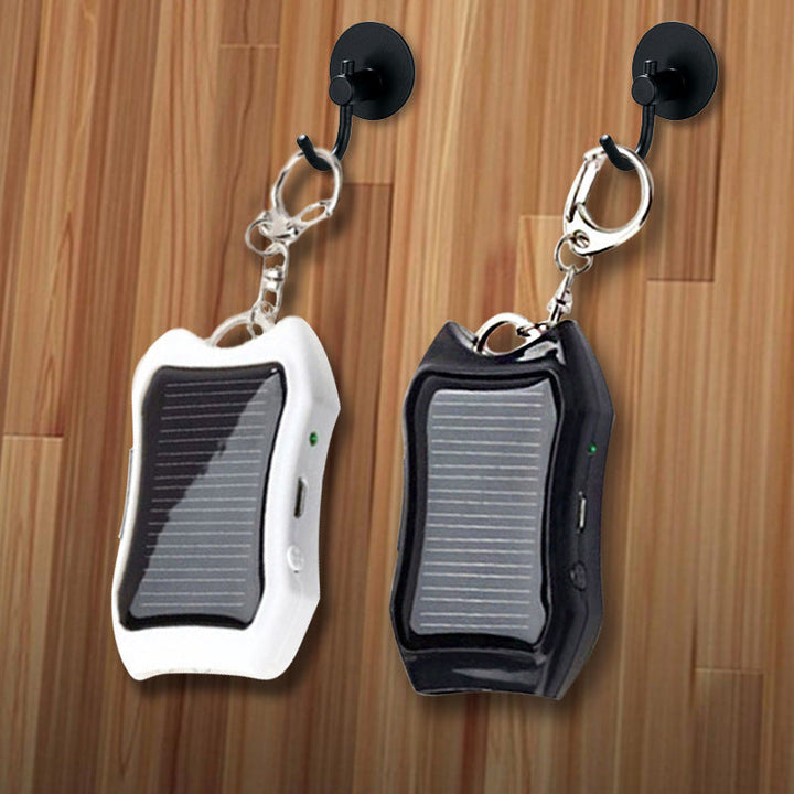 Bärbar mini powerbank på nyckelring, svart och vit, kompakt design, perfekt för resor och enkel att bära med sig.