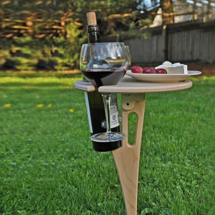 "Bärbart vinbord i björk, fällbar design, för utomhusbruk med plats för vinflaska, glas och snacks, perfekt för picknick."