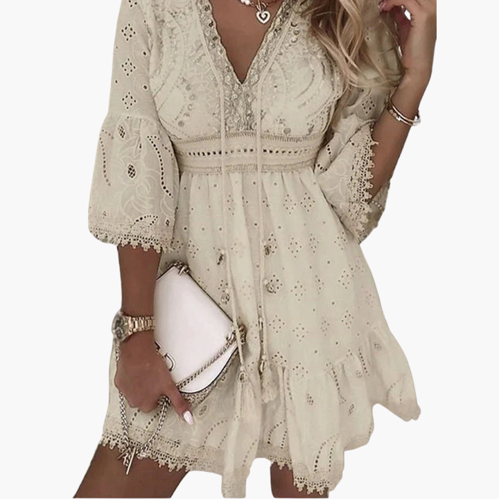 Beige kort damklänning med V-ringning, utsvängda ärmar och broderade detaljer, sommarstil.