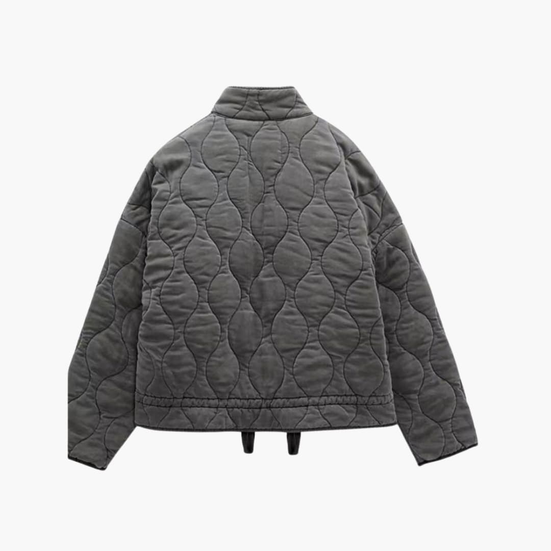 Stilren grå quiltad damjacka med praktiska fickor. En elegant vinterjacka för kvinnor, perfekt som vardagsplagg.