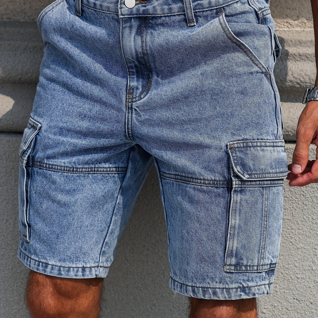 Detalj av midjeband på Urban Denim herrshorts, med knapp och bälteshällor, praktisk för en bekväm passform.