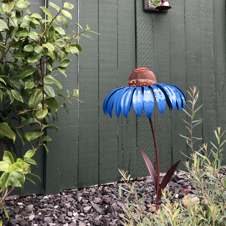 "Blommig järn fågelmatare, formad som blomma, i rött eller blått, perfekt för att locka fåglar i trädgården."
