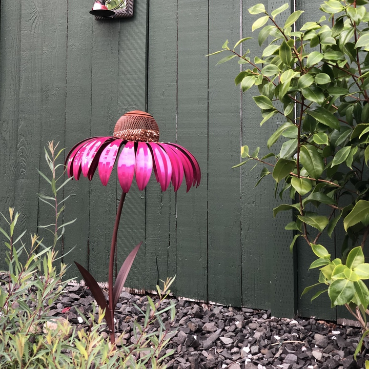 "Blommig järn fågelmatare, formad som blomma, i rött eller blått, perfekt för att locka fåglar i trädgården."