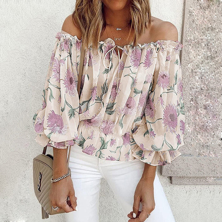 Blommig off shoulder volangblus dam med puffärmar i chiffong. Elegant och feminin topp för stilmedvetna kvinnor.