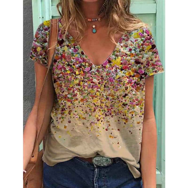 "Blommig V-ringad kortärmad t-shirt med unik blommönster, sedd framifrån. Perfekt för vår- och sommardagar."