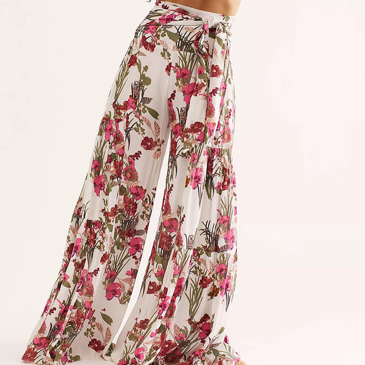 Blommiga vida byxor med elastisk midja för kvinnor, luftiga ben och färgglada blommönster, elegant och bekväm stil.