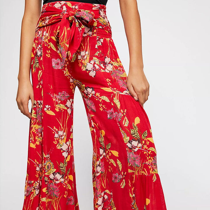 Blommiga vida byxor med elastisk midja för kvinnor, luftiga ben och färgglada blommönster, elegant och bekväm stil.