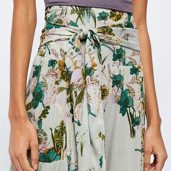Blommiga vida byxor med elastisk midja för kvinnor, luftiga ben och färgglada blommönster, elegant och bekväm stil.