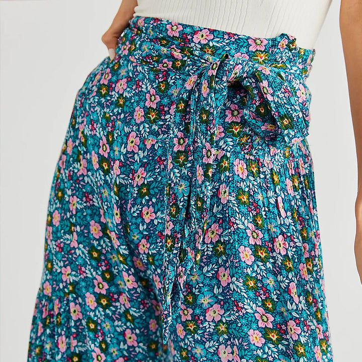 Blommiga vida byxor med elastisk midja för kvinnor, luftiga ben och färgglada blommönster, elegant och bekväm stil.