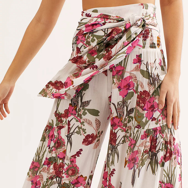 Blommiga vida byxor med elastisk midja för kvinnor, luftiga ben och färgglada blommönster, elegant och bekväm stil.