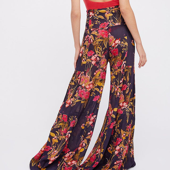 Blommiga vida byxor med elastisk midja för kvinnor, luftiga ben och färgglada blommönster, elegant och bekväm stil.