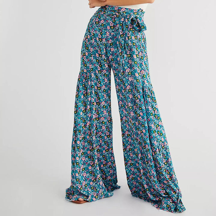 Blommiga vida byxor med elastisk midja för kvinnor, luftiga ben och färgglada blommönster, elegant och bekväm stil.