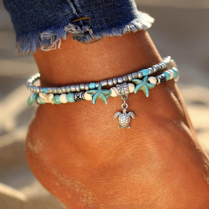 "Bohemisk havssköldpadda vristlänk med turkos pärlor, justerbar passform för ankel. Perfekt boho-chic strandaccessoar."