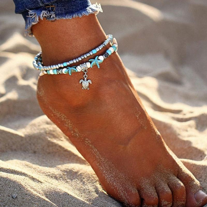 "Bohemisk havssköldpadda vristlänk med turkos pärlor, justerbar passform för ankel. Perfekt boho-chic strandaccessoar."