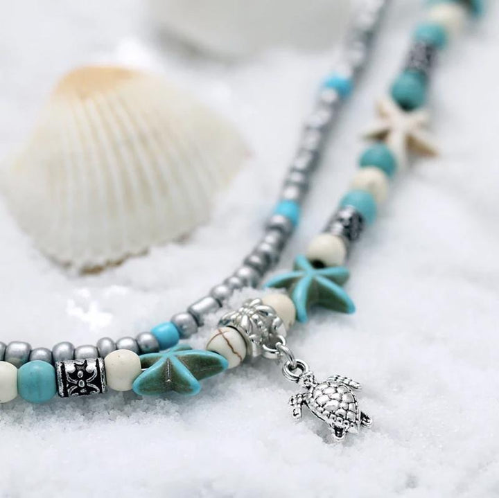"Bohemisk havssköldpadda vristlänk med turkos pärlor, justerbar passform för ankel. Perfekt boho-chic strandaccessoar."