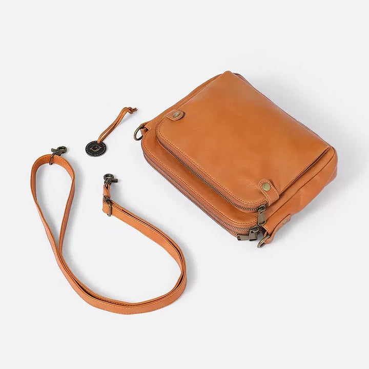 "Brun läder damväska, multifunktionell crossbody, elegant design, rymmer iPad, med RFID-skydd, modern look."