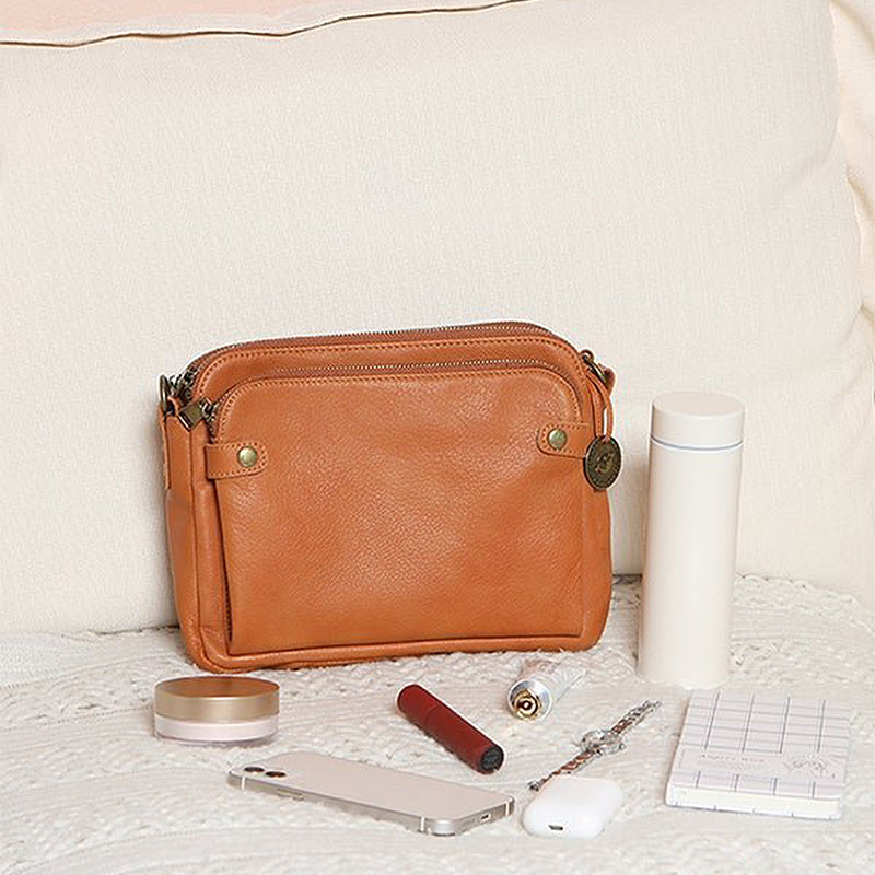 "Brun läder damväska, multifunktionell crossbody, elegant design, rymmer iPad, med RFID-skydd, modern look."